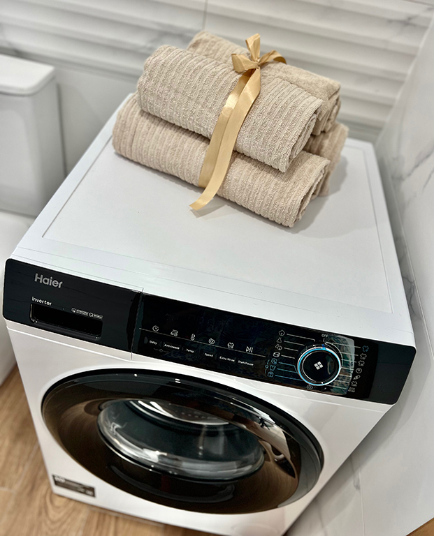 Washing machine in the apartment bathroom, discreetly integrated into the functional space.