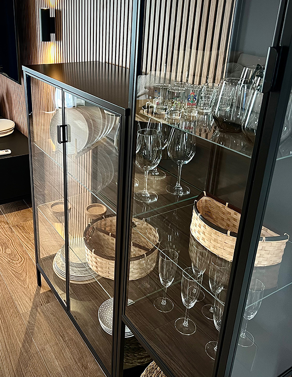 Detail of the living room in the Ocean View Luxury apartment - glass display case with glasses and decorations.