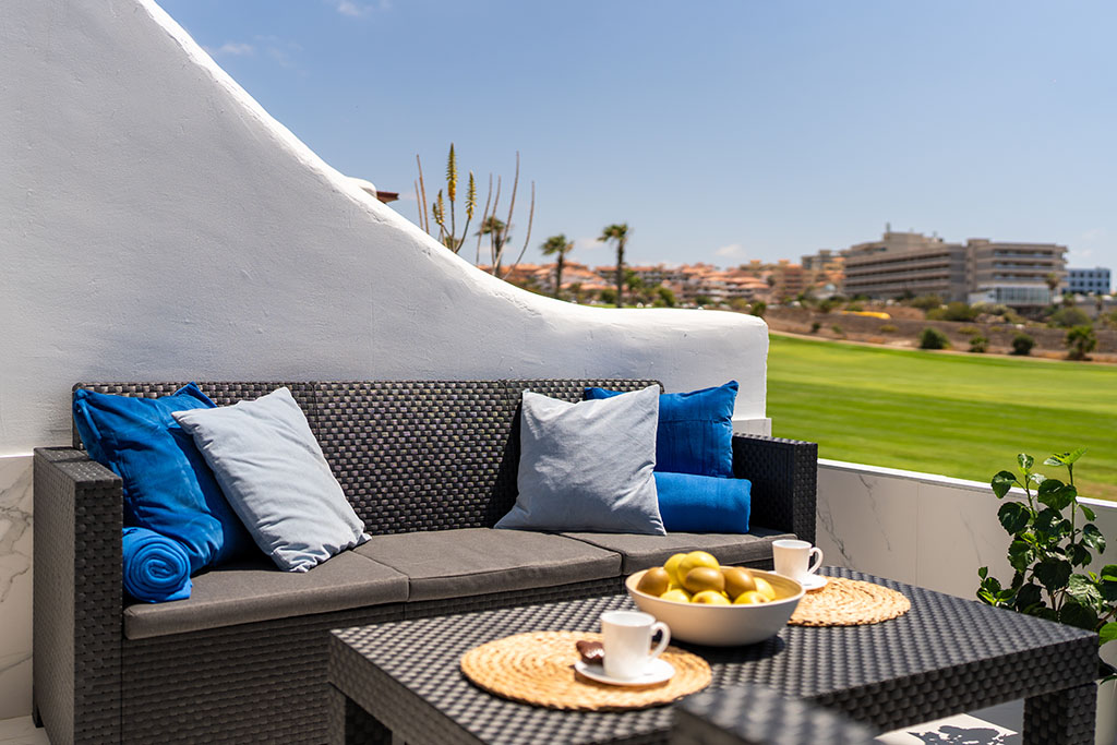 Terrace of Amarilla Golf Marina Vista Mar apartment with a comfortable sofa and views of the golf course.