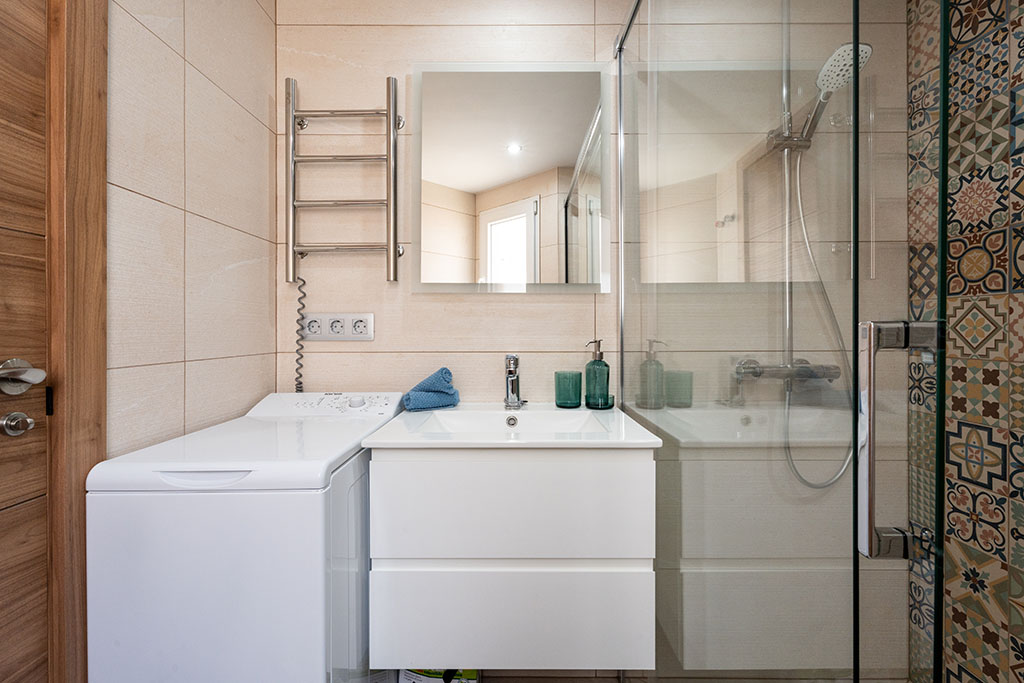 Modern bathroom in Amarilla Golf Marina Vista Mar with washing machine, clear construction and functional design.