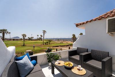 Relaxation area on the apartment terrace with panoramic views of the green golf course.