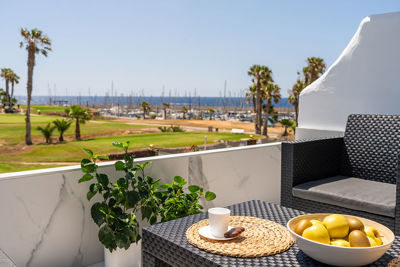 Terrace in Amarilla Golf with relaxation area and views of the marina and coastal surroundings.