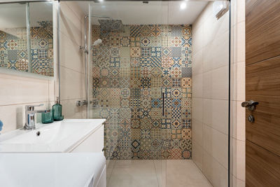 Apartment bathroom with decorative Mediterranean-style tiles and elegant finish.