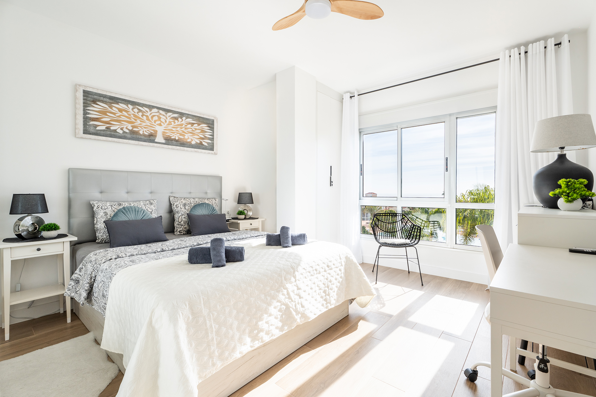 Stylowo urządzona sypialnia z podwójnym łóżkiem i naturalnym światłem w apartamencie wakacyjnym na Wyspach Kanaryjskich.
