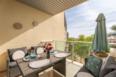 Spacious terrace of the apartment in the Canary Islands, furnished with a table and plates of food, perfect for outdoor enjoyment.