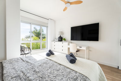 Spacious room featuring modern decor and a flat-screen TV in a luxury apartment located in the Canary Islands.