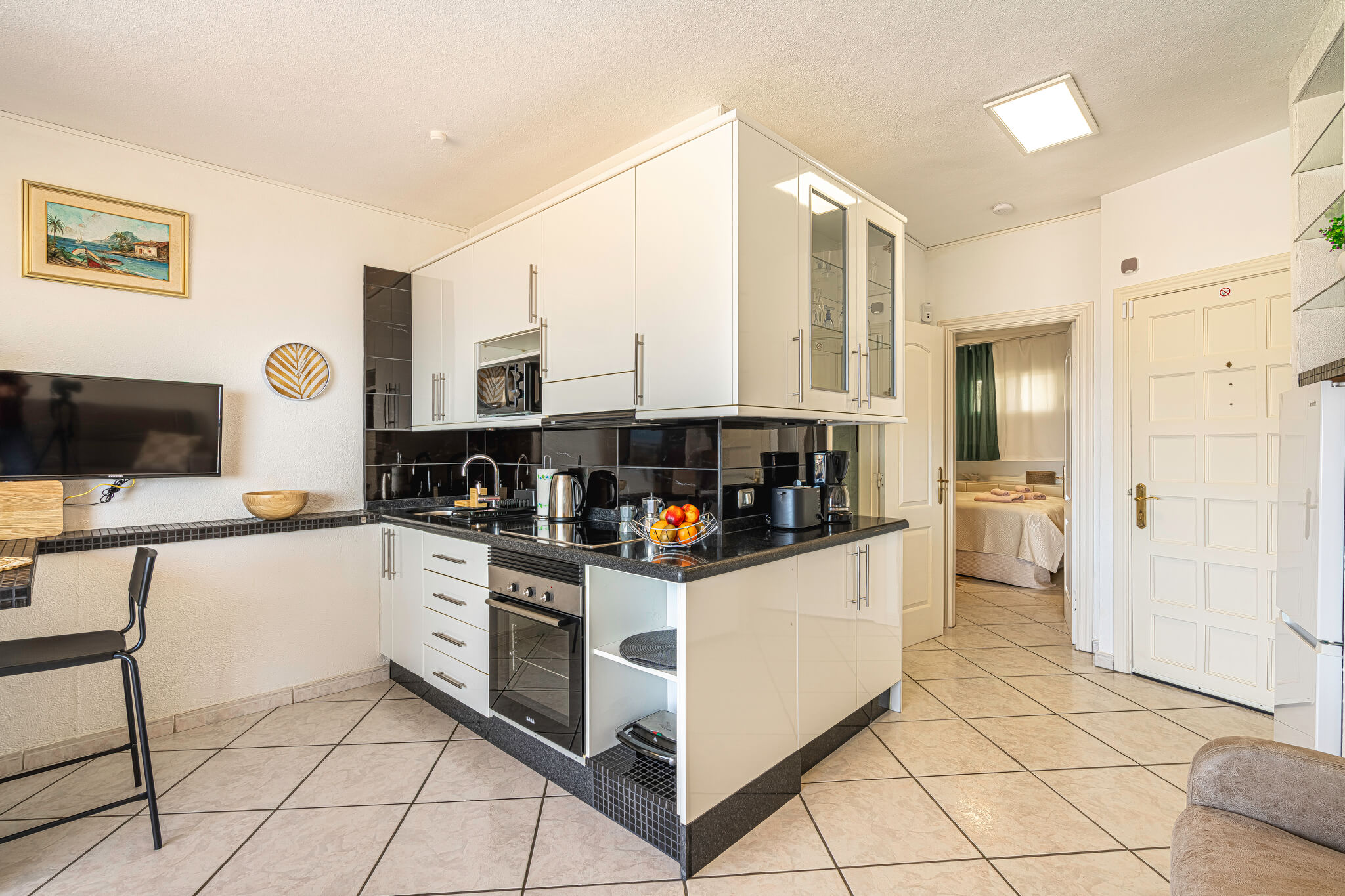 Well-equipped kitchen with light tiles and stainless steel appliances in a vacation rental in the Canary Islands