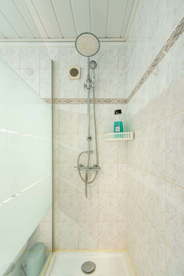 Modern bathroom featuring a spacious shower with elegant finishes in the Sol del Sur apartment, located in the Canary Islands, Spain.
