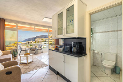 Bright living room featuring comfortable sofas and windows providing ocean views in a vacation rental in the Canary Islands, Spain.